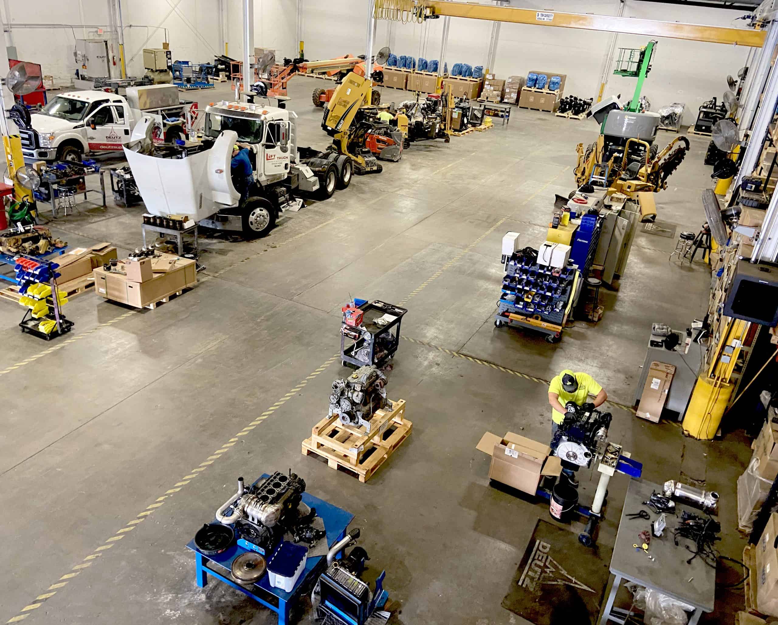 DPC MW (4)_PS Busy industrial workshop with mechanics and machinery.