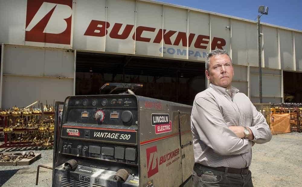 Man standing near industrial equipment outside building