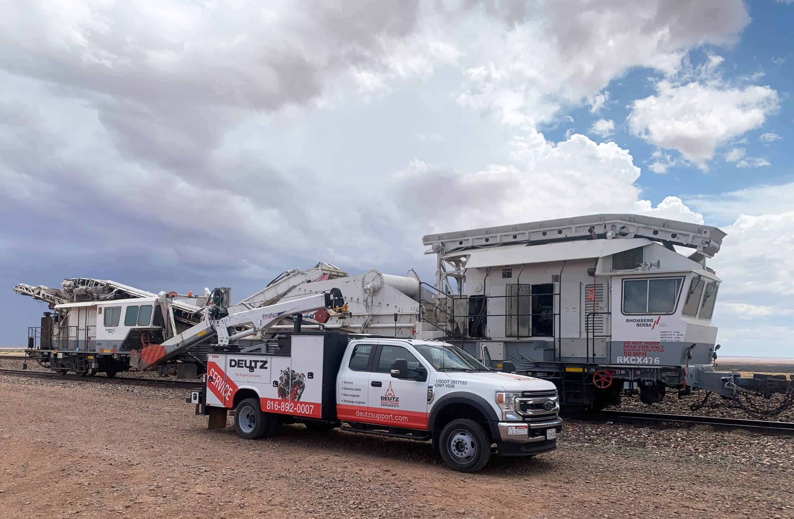 Service truck near railroad maintenance vehicle.