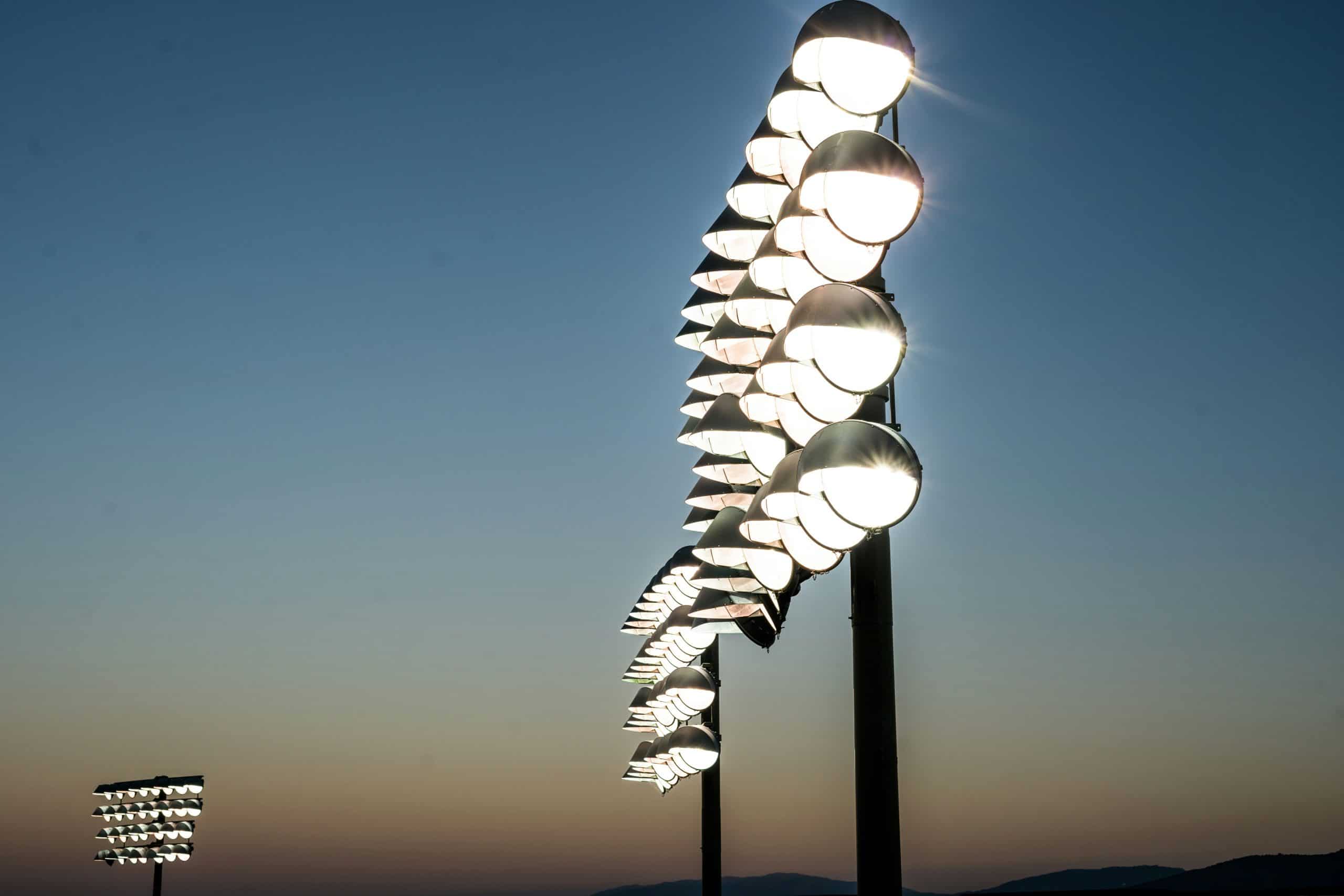 Stadium floodlights glowing against evening sky